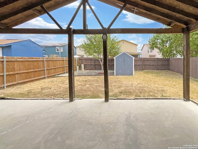 view of patio with a fenced backyard, an outdoor structure, and a storage unit