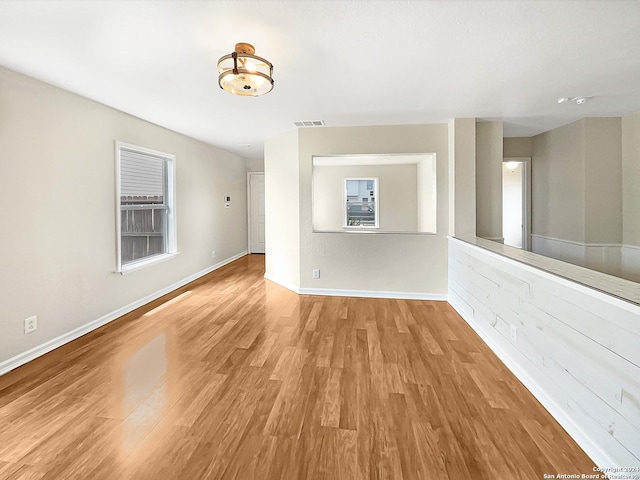 empty room with visible vents, baseboards, and wood finished floors