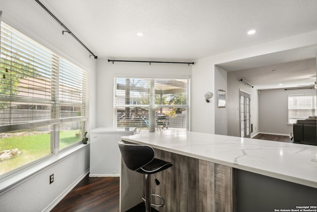 kitchen featuring dark wood-type flooring and light stone countertops