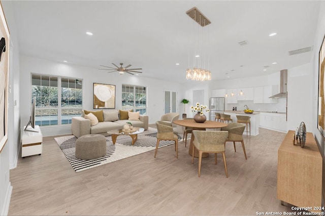 dining space with ceiling fan with notable chandelier, light wood-type flooring, visible vents, and recessed lighting