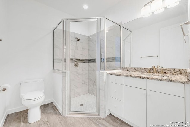 full bathroom with toilet, a stall shower, wood finished floors, and vanity