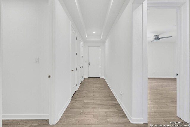 corridor featuring recessed lighting, light wood-type flooring, and baseboards