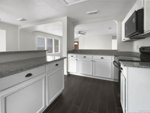 kitchen featuring dark wood-type flooring, black range with electric stovetop, visible vents, white cabinetry, and dark stone counters