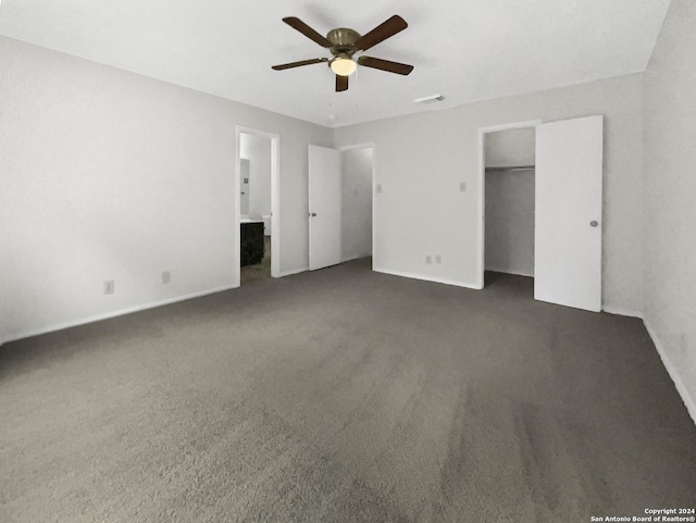 unfurnished bedroom with a ceiling fan, visible vents, dark carpet, and connected bathroom