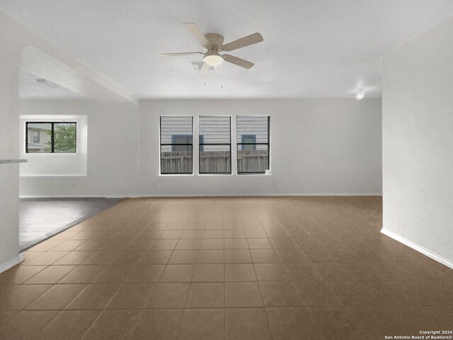 tiled spare room with ceiling fan