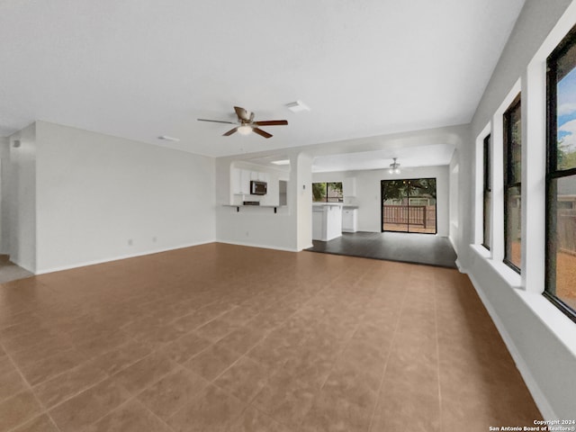 unfurnished living room with ceiling fan and tile patterned flooring