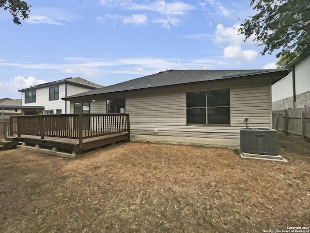 rear view of house with central air condition unit, fence, and a deck