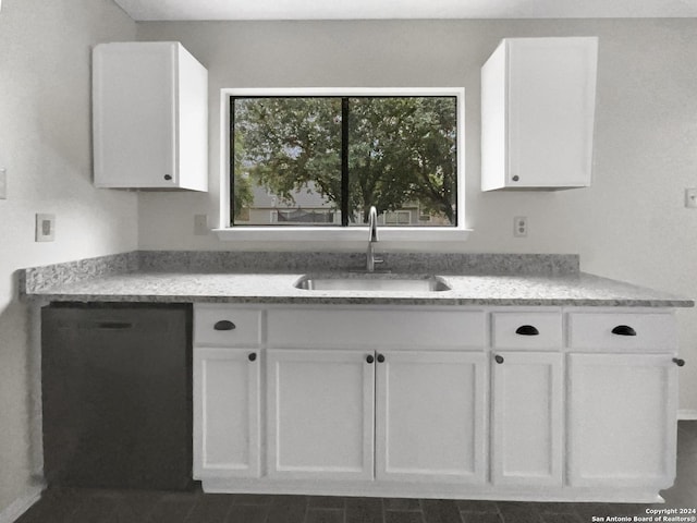 kitchen with black dishwasher, white cabinetry, and a sink