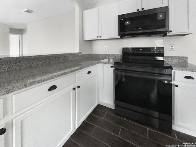 kitchen featuring electric range, visible vents, white cabinets, arched walkways, and light stone countertops