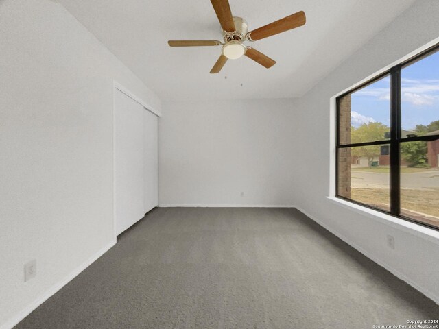 empty room with ceiling fan and carpet flooring