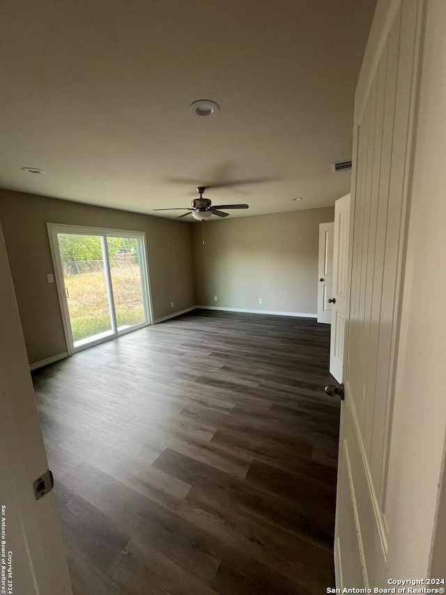 empty room featuring dark hardwood / wood-style flooring and ceiling fan