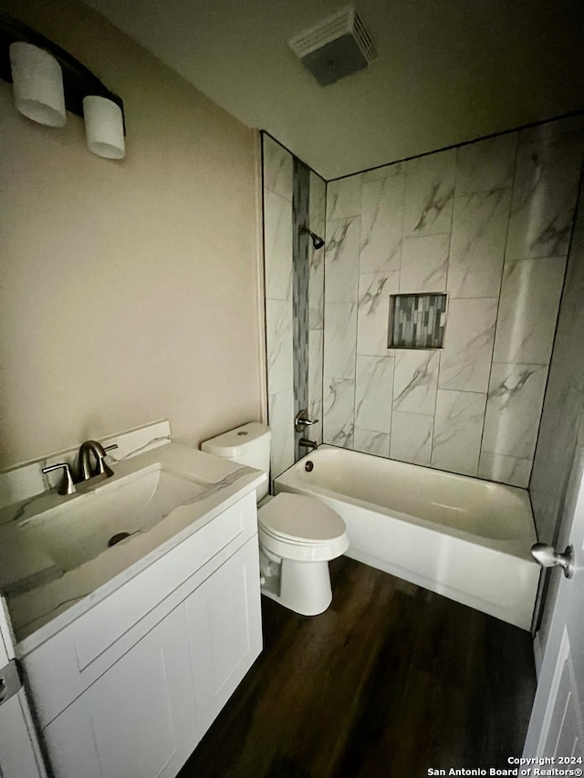 full bathroom featuring vanity, toilet, tiled shower / bath combo, and hardwood / wood-style floors