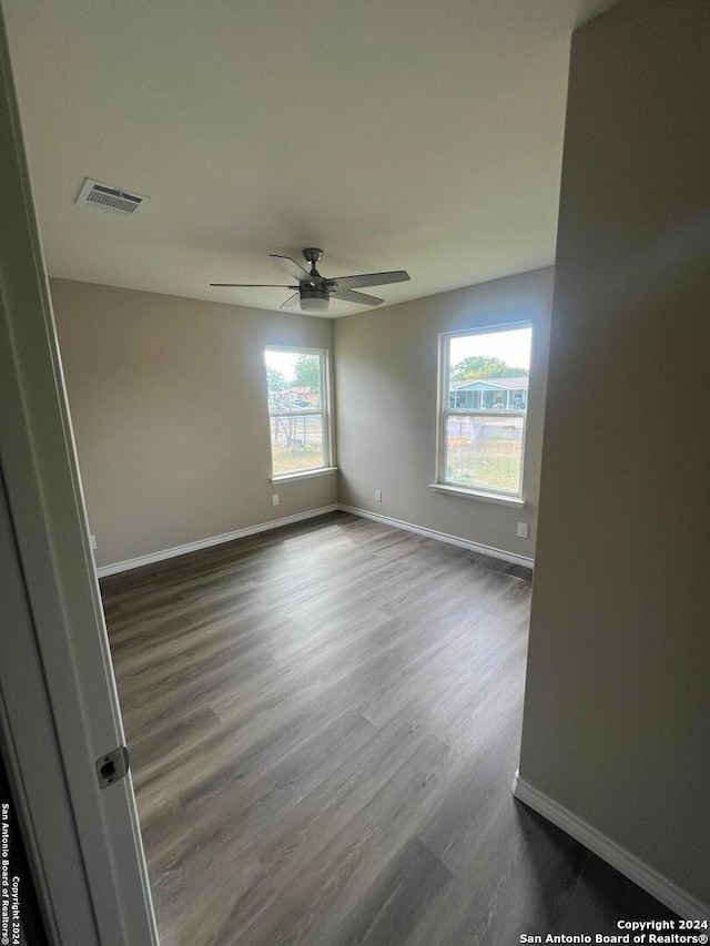 spare room with ceiling fan and dark hardwood / wood-style floors