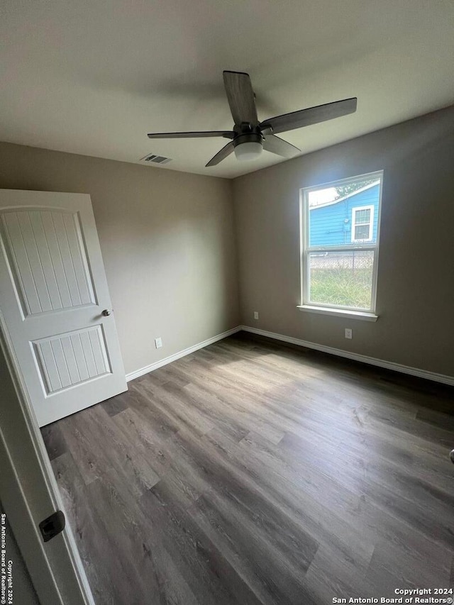 empty room with ceiling fan and dark hardwood / wood-style floors