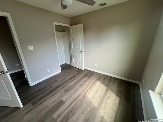 unfurnished bedroom featuring hardwood / wood-style floors, ceiling fan, and a closet