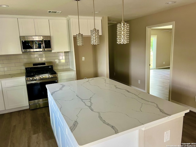 kitchen featuring stainless steel appliances, backsplash, dark hardwood / wood-style flooring, and white cabinets