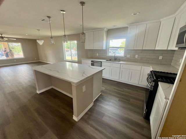 kitchen with a kitchen island, decorative backsplash, dark hardwood / wood-style flooring, and a healthy amount of sunlight