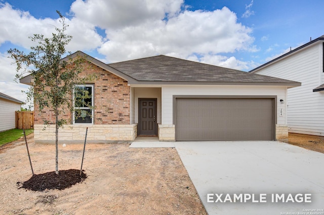 ranch-style house with stone siding, a shingled roof, an attached garage, and driveway