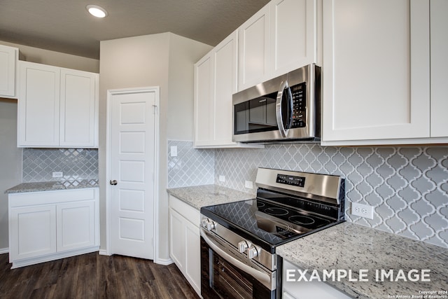 kitchen featuring appliances with stainless steel finishes, white cabinetry, and light stone countertops