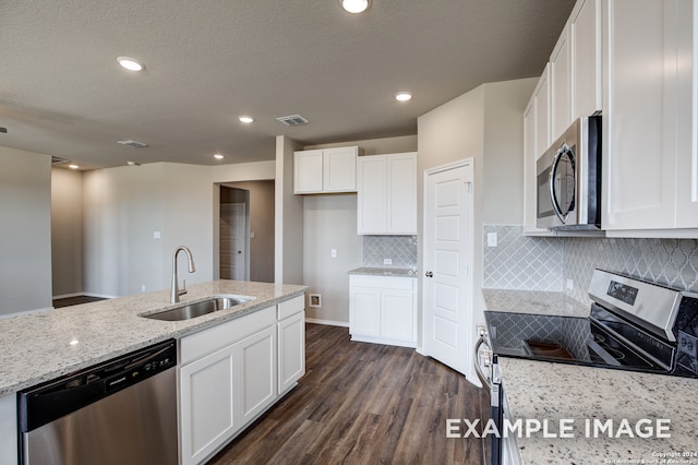 kitchen with appliances with stainless steel finishes, white cabinets, a sink, and light stone countertops