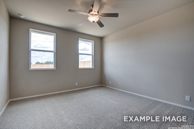 spare room with carpet flooring, ceiling fan, and baseboards