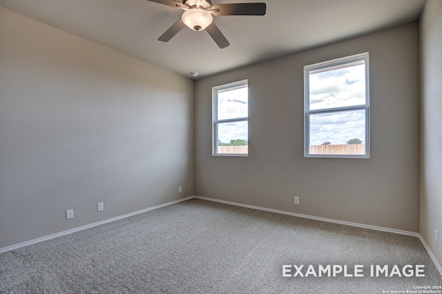 spare room featuring carpet, a ceiling fan, and baseboards