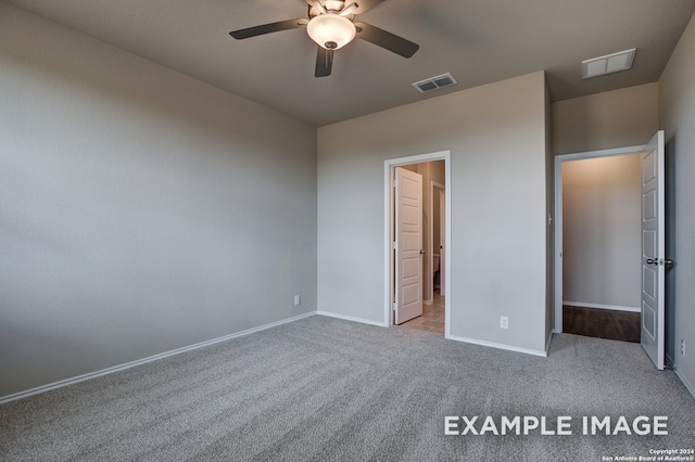 unfurnished bedroom featuring baseboards, visible vents, and light colored carpet