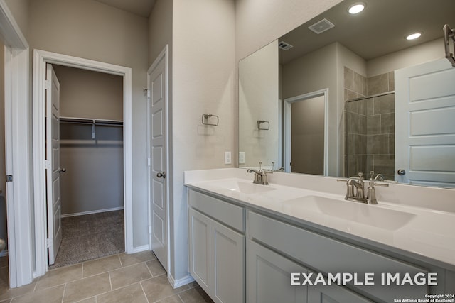 full bath with a walk in closet, visible vents, a sink, and double vanity