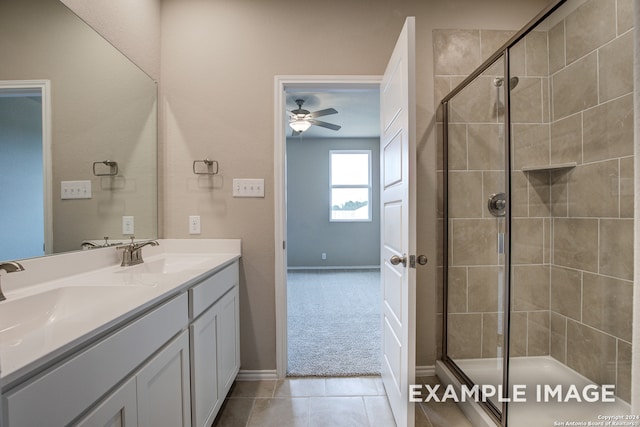 bathroom with double vanity, tile patterned flooring, a sink, and a shower stall