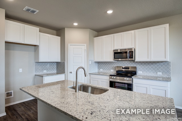 kitchen with appliances with stainless steel finishes, visible vents, a sink, and white cabinetry