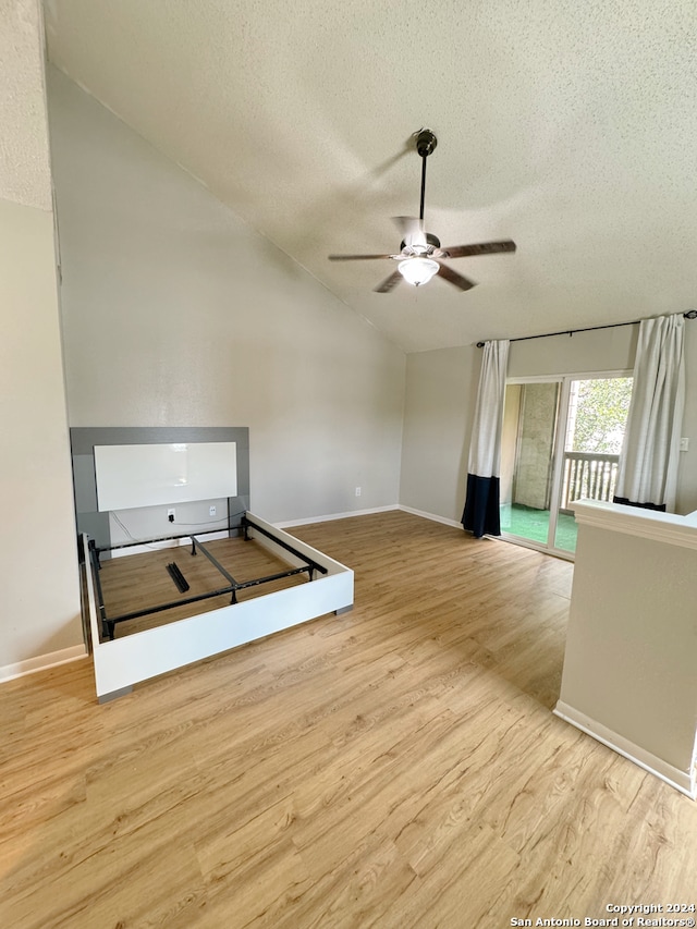 interior space featuring a textured ceiling, light hardwood / wood-style flooring, lofted ceiling, and ceiling fan