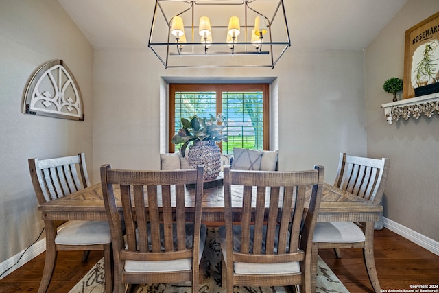 dining room with lofted ceiling, an inviting chandelier, and wood-type flooring