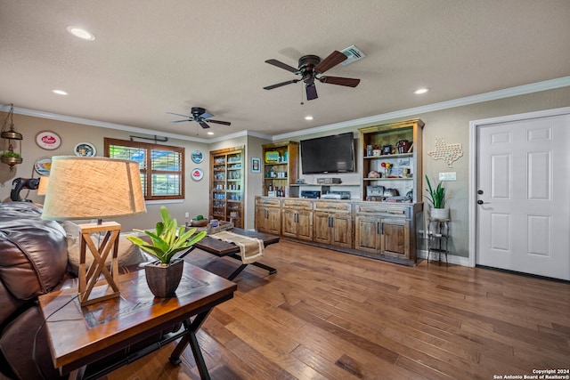 living room with ceiling fan, dark wood-type flooring, a textured ceiling, and crown molding