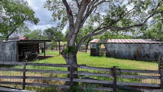 view of yard featuring an exterior structure, an outdoor structure, and an outbuilding