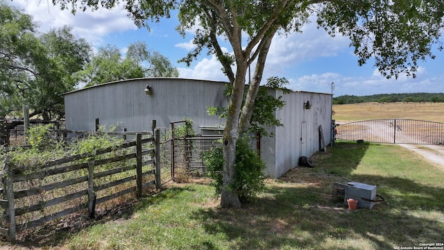 view of pole building with a yard, fence, and a gate