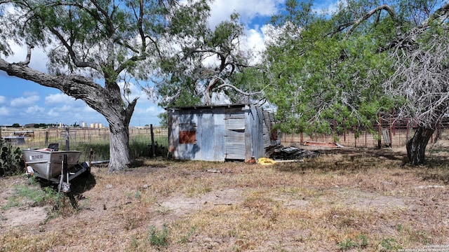 view of yard with an outbuilding, a storage unit, and fence