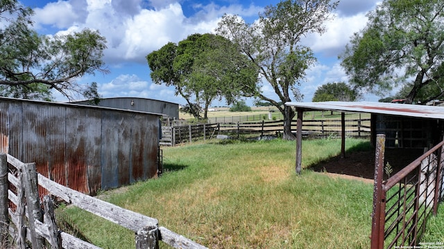 view of yard with a rural view and an outdoor structure