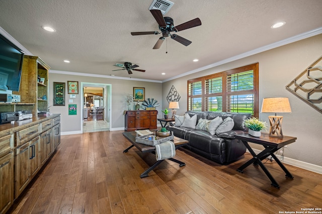 living room with ceiling fan, dark hardwood / wood-style floors, crown molding, and a textured ceiling