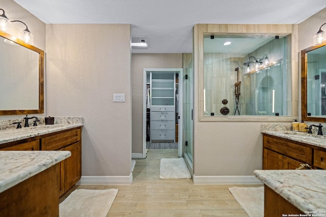 full bath featuring a spacious closet, a tile shower, a sink, and wood finished floors