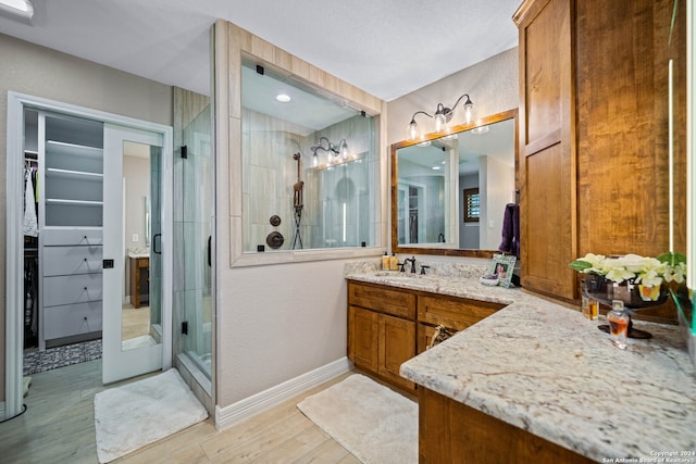 bathroom featuring hardwood / wood-style flooring, walk in shower, and vanity