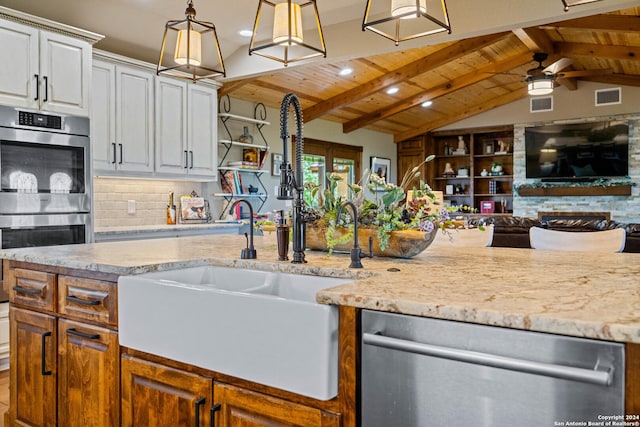 kitchen featuring open floor plan, a ceiling fan, decorative backsplash, stainless steel appliances, and vaulted ceiling with beams