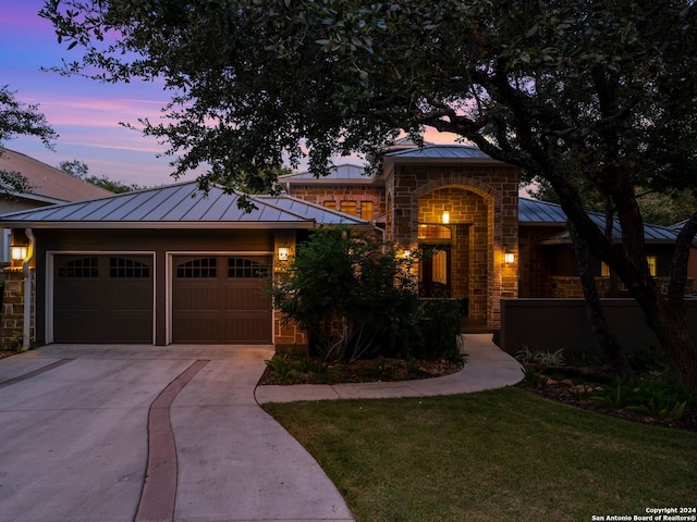 view of front facade with a garage and a lawn