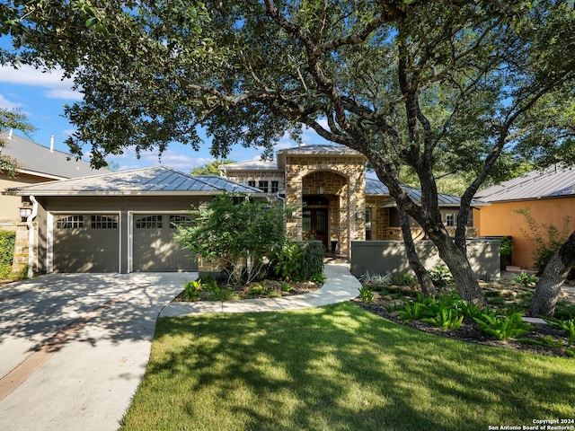 view of front of home with a garage and a front lawn