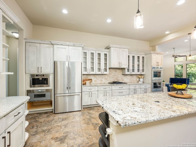 kitchen with stainless steel appliances, tasteful backsplash, white cabinets, light tile patterned floors, and ceiling fan