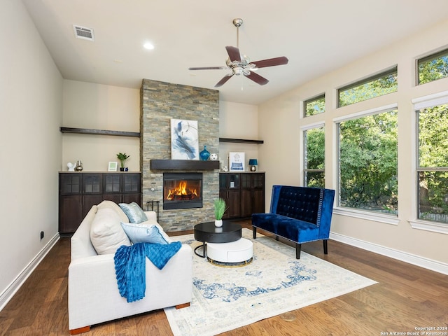 living room with ceiling fan, dark hardwood / wood-style flooring, and a fireplace