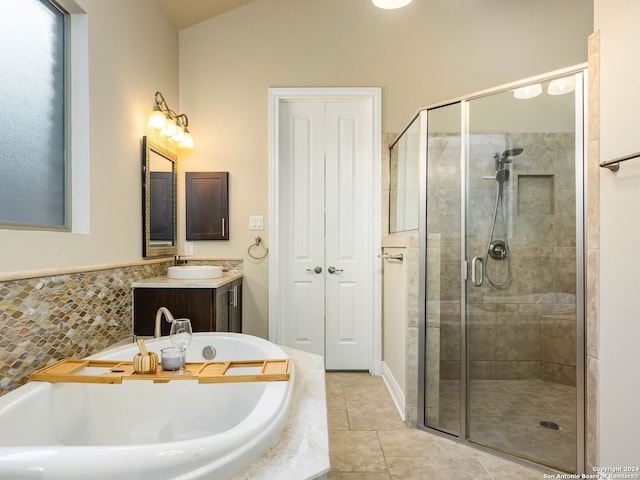 bathroom with tile patterned flooring, independent shower and bath, and vanity