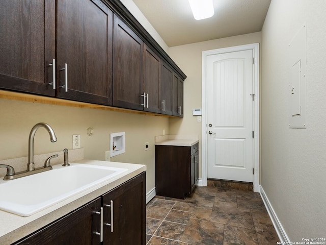 laundry area with electric dryer hookup, cabinets, hookup for a washing machine, sink, and dark tile patterned floors