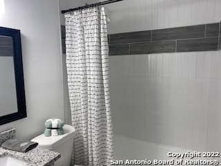 bathroom with toilet and a shower with shower curtain