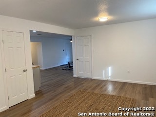 unfurnished room with dark wood-type flooring