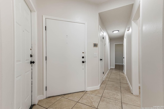 hallway with baseboards and light tile patterned floors